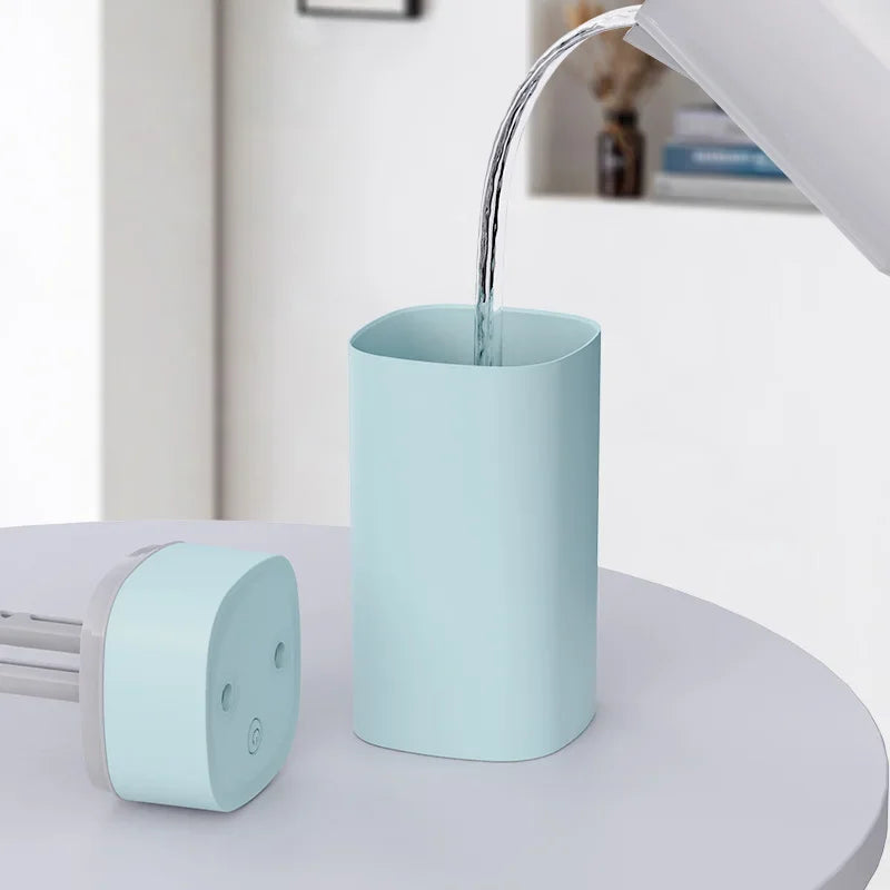 Light blue electronic device with a water faucet-like feature on a white surface.